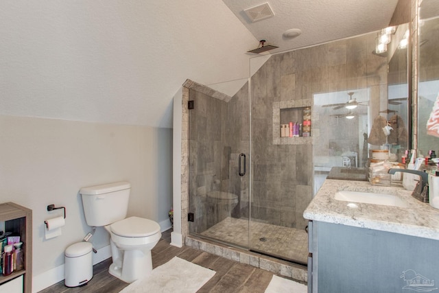 full bath with vaulted ceiling, a textured ceiling, a stall shower, wood finished floors, and toilet