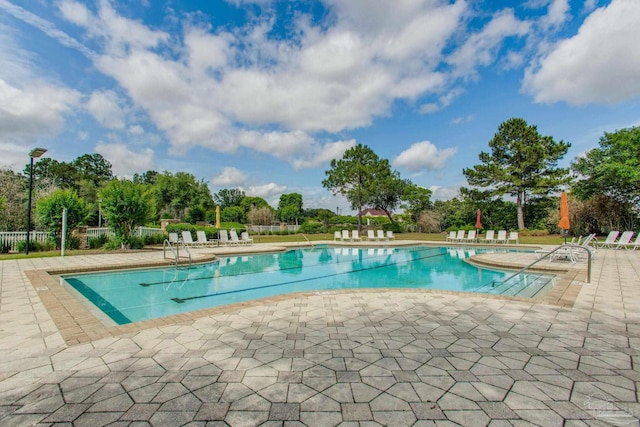 community pool with a patio and fence