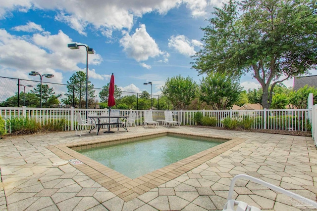 view of swimming pool with a patio and fence