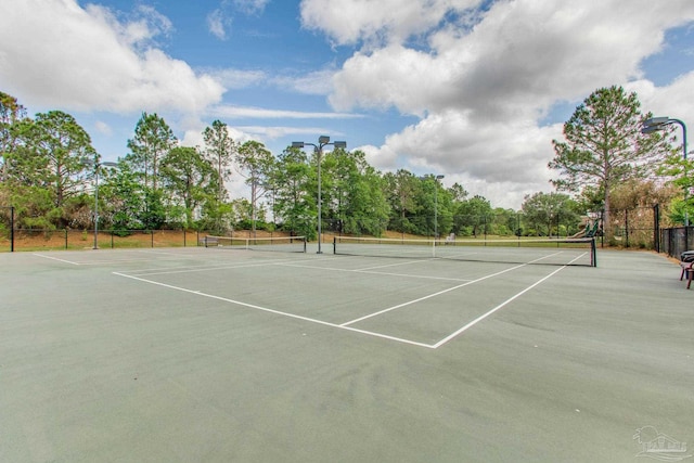 view of tennis court with fence and community basketball court