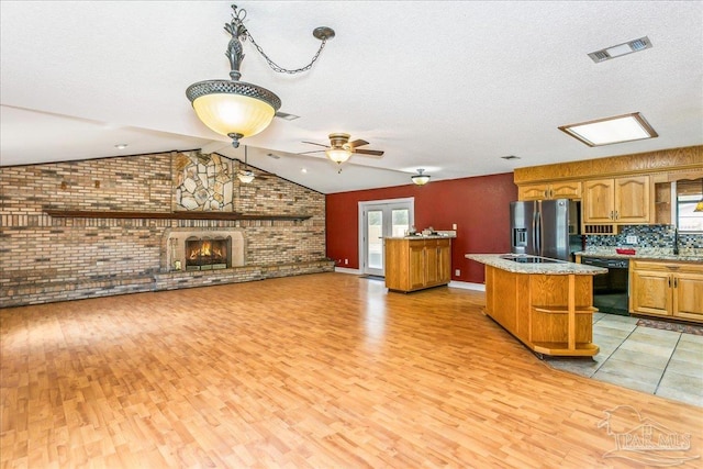 kitchen with light wood-style flooring, dishwasher, a kitchen island, and stainless steel fridge with ice dispenser