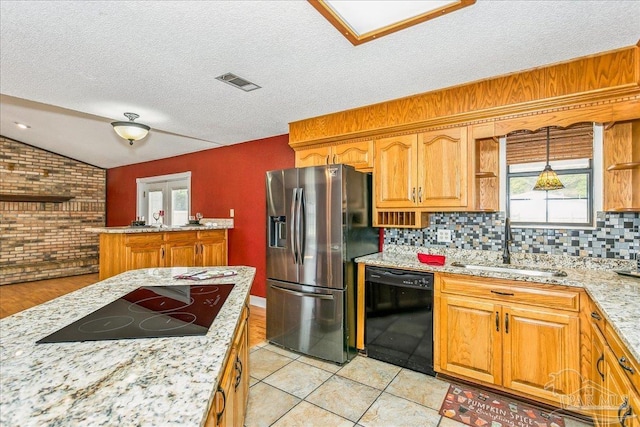 kitchen featuring visible vents, a wealth of natural light, a sink, and black appliances