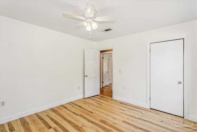 unfurnished bedroom featuring baseboards, a ceiling fan, light wood-style flooring, and visible vents