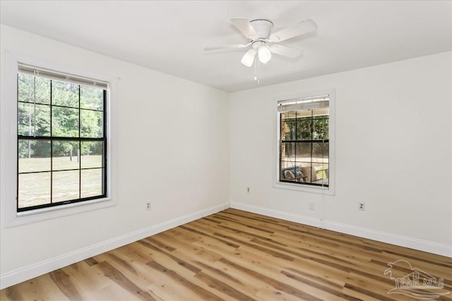 unfurnished room with light wood-type flooring, baseboards, ceiling fan, and a healthy amount of sunlight
