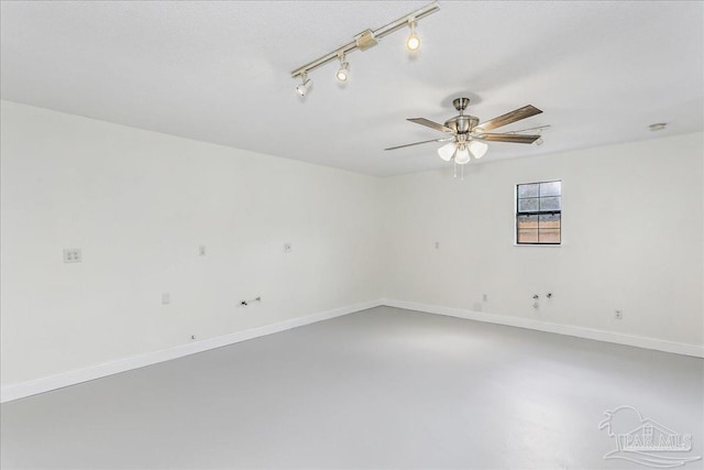 empty room with a ceiling fan, baseboards, and concrete floors