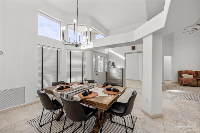 tiled dining space with a high ceiling and a notable chandelier