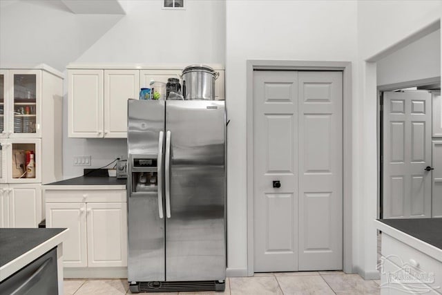 kitchen with stainless steel appliances, white cabinetry, and light tile patterned floors