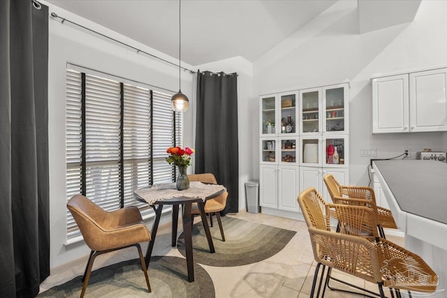 tiled dining room with vaulted ceiling