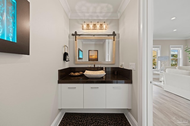 bathroom featuring vanity, crown molding, baseboards, and recessed lighting