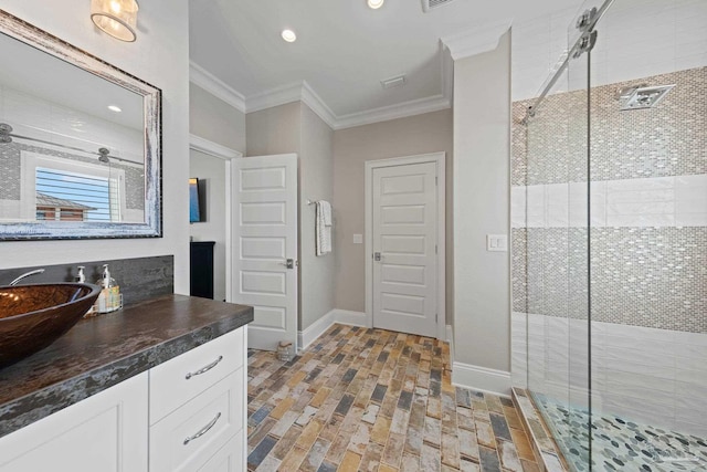 bathroom featuring vanity, ornamental molding, baseboards, and a shower stall