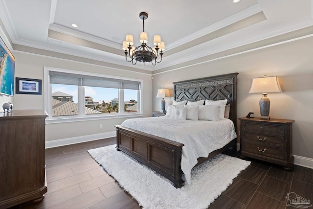 bedroom with a tray ceiling, baseboards, a notable chandelier, and ornamental molding