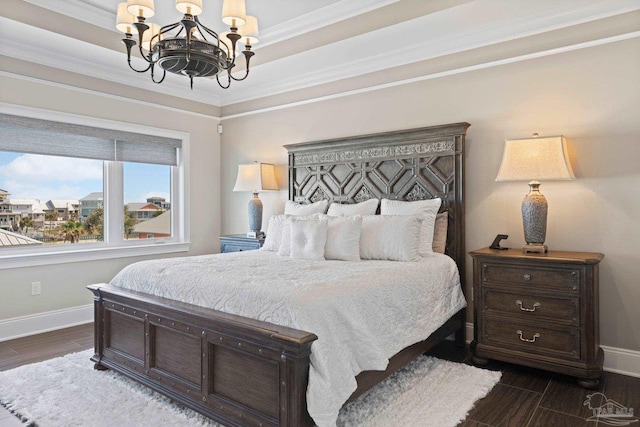 bedroom featuring crown molding, baseboards, dark wood-type flooring, a tray ceiling, and a notable chandelier
