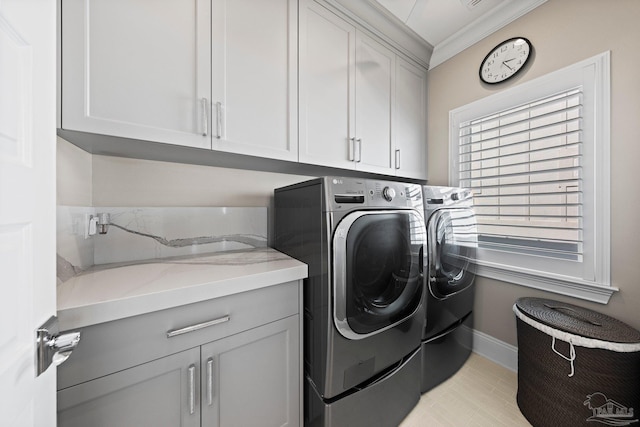 washroom featuring washer and clothes dryer, cabinet space, ornamental molding, and baseboards