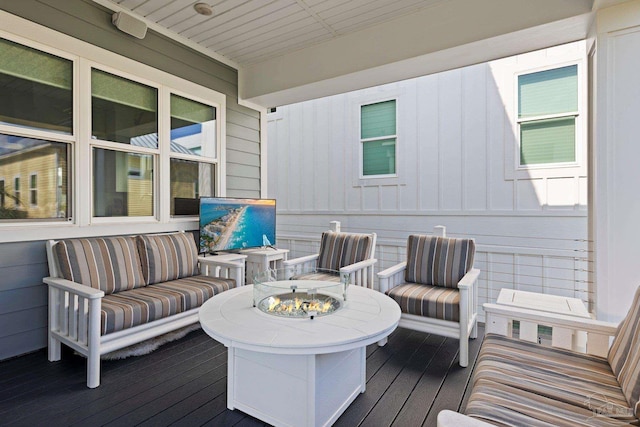 wooden terrace featuring an outdoor living space with a fire pit