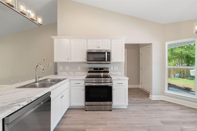 kitchen featuring light wood-type flooring, appliances with stainless steel finishes, sink, and white cabinetry