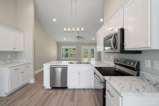 kitchen featuring sink, light wood-type flooring, ceiling fan, stainless steel appliances, and kitchen peninsula