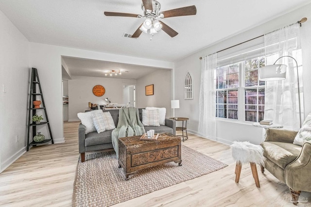 living room with ceiling fan and light hardwood / wood-style floors