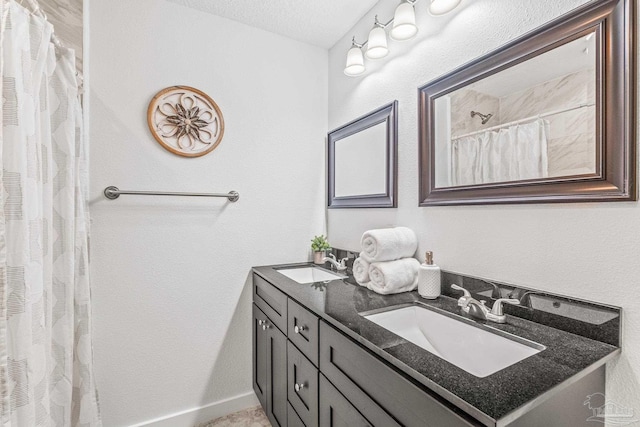 bathroom featuring a shower with curtain, vanity, and a textured ceiling