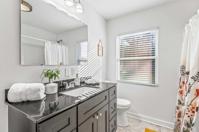 bathroom featuring vanity, toilet, and a wealth of natural light