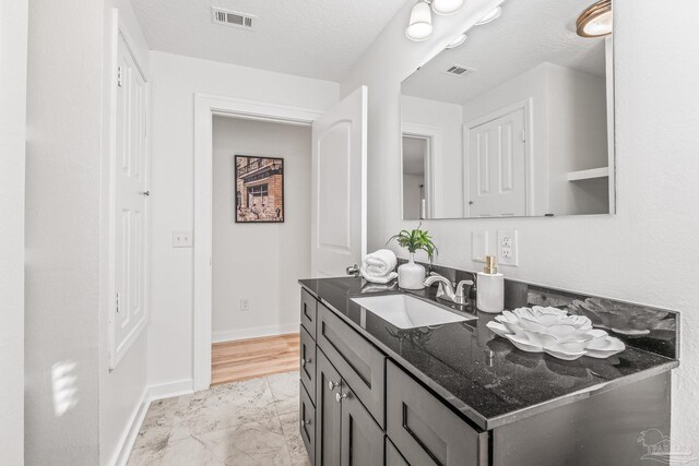 bathroom with vanity and a textured ceiling