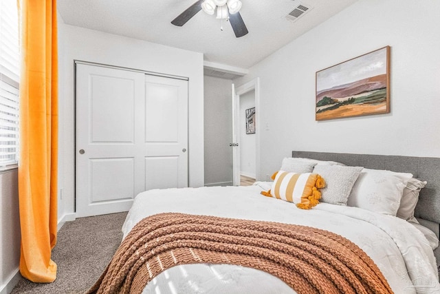 bedroom featuring ceiling fan, a closet, carpet floors, and a textured ceiling