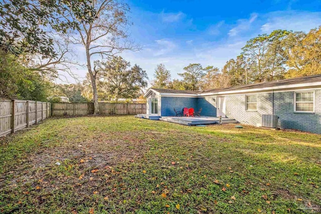 view of yard featuring central AC unit and a wooden deck