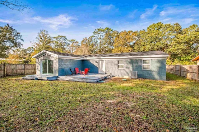 rear view of house featuring a yard, central AC, and a wooden deck