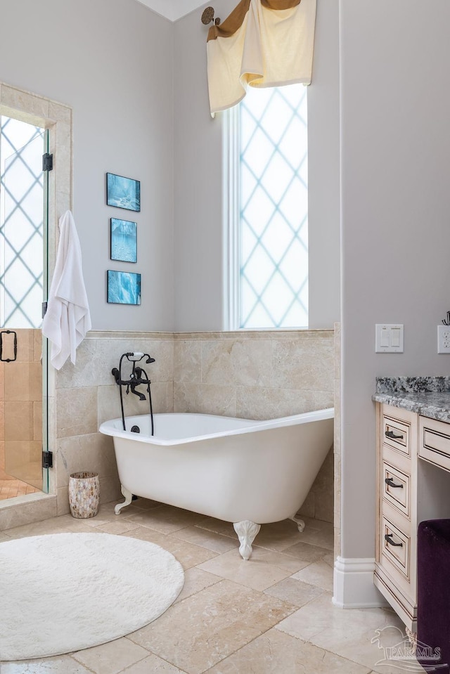 3063 Bay St, Gulf Breeze, FL 32563 - full bath featuring tile walls, healthy amount of natural light, a soaking tub, wainscoting, and vanity