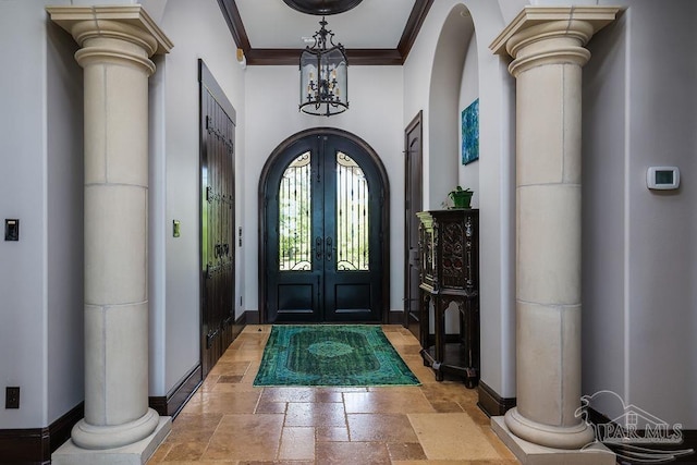 3063 Bay St, Gulf Breeze, FL 32563 - foyer entrance with decorative columns, baseboards, stone tile flooring, ornamental molding, and arched walkways