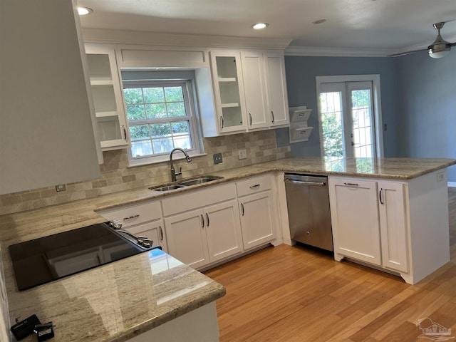 kitchen featuring crown molding, white cabinetry, a sink, dishwasher, and a peninsula