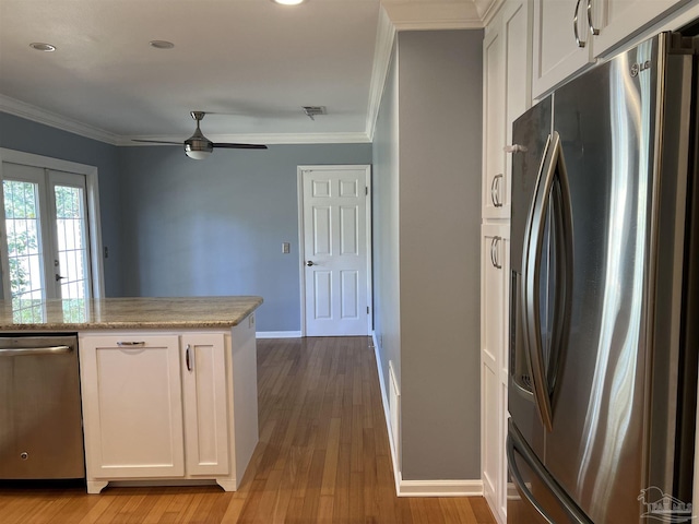 kitchen with appliances with stainless steel finishes, white cabinets, and crown molding