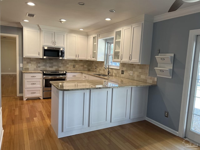 kitchen with light stone counters, a sink, visible vents, white cabinetry, and appliances with stainless steel finishes