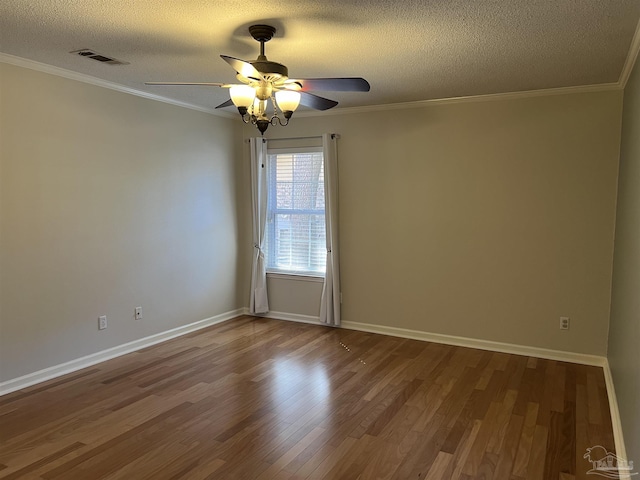 empty room with visible vents, crown molding, a textured ceiling, and wood finished floors