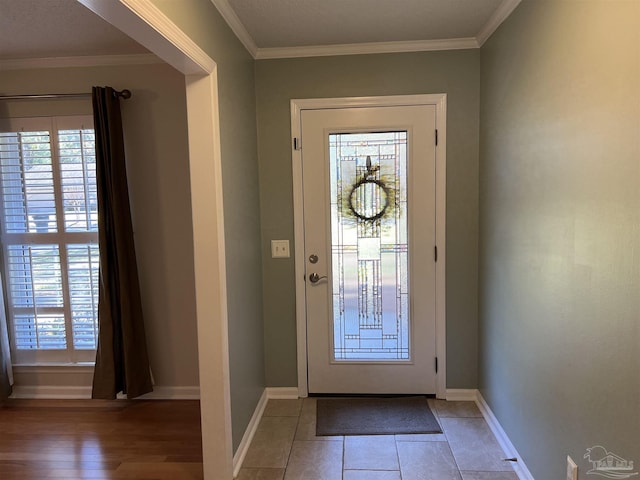 entryway featuring crown molding, baseboards, and light tile patterned floors