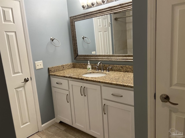 bathroom featuring tile patterned flooring, vanity, and baseboards