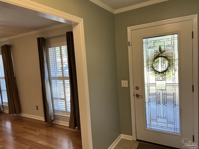 entryway with ornamental molding, baseboards, and wood finished floors