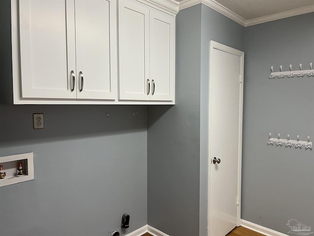 clothes washing area featuring hookup for a washing machine, cabinet space, ornamental molding, and baseboards