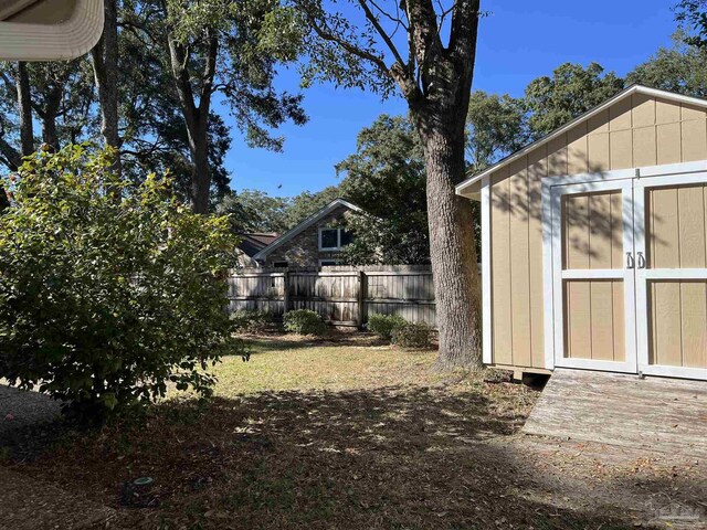 view of yard with an outbuilding, a shed, and fence