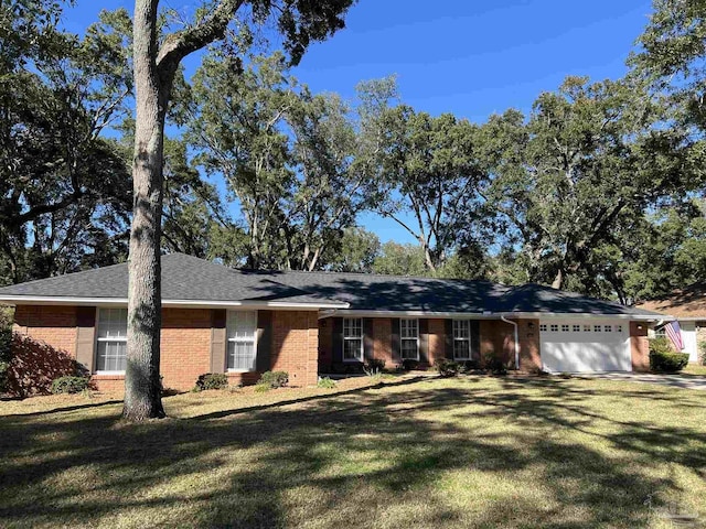 single story home featuring a front yard, brick siding, and an attached garage