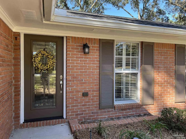 property entrance featuring brick siding