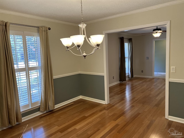 unfurnished room featuring ornamental molding, a textured ceiling, baseboards, and wood finished floors