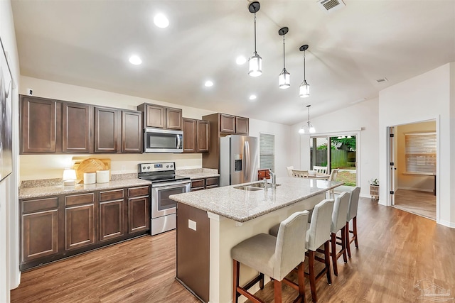 5853 Fairlands Rd, Milton, FL 32583 - kitchen featuring stainless steel appliances, a sink, vaulted ceiling, a center island with sink, and light wood-type flooring