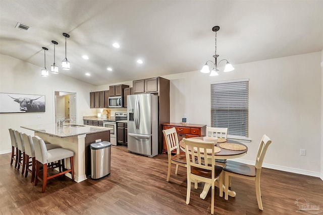 5853 Fairlands Rd, Milton, FL 32583 - kitchen featuring stainless steel appliances, a sink, dark wood-style floors, lofted ceiling, and a center island with sink