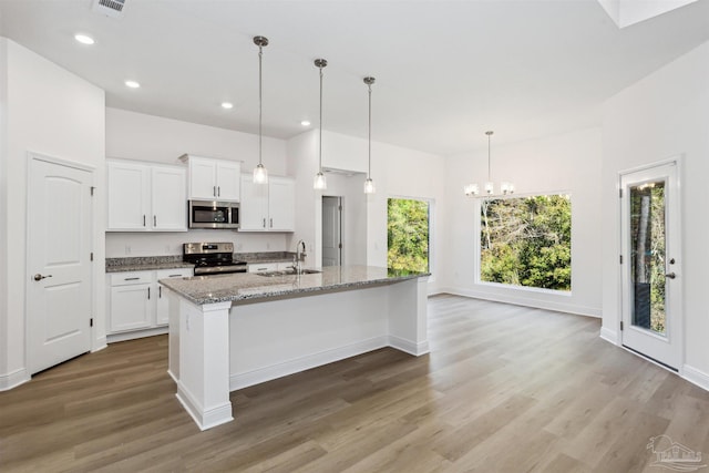 kitchen featuring an island with sink, white cabinetry, stainless steel appliances, and sink