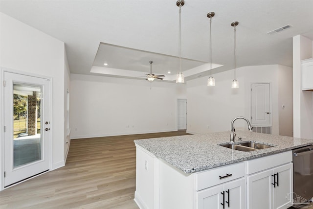 kitchen with white cabinets, stainless steel dishwasher, decorative light fixtures, a raised ceiling, and sink