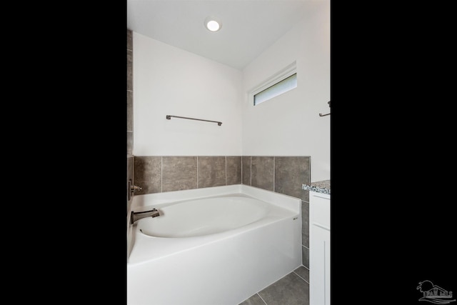 bathroom featuring vanity, tile patterned flooring, and a bathtub