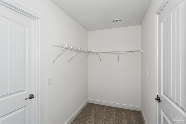 spacious closet with dark carpet