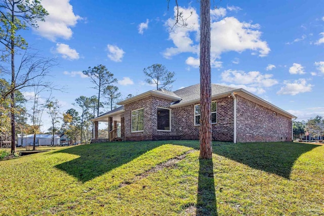 rear view of property featuring a lawn