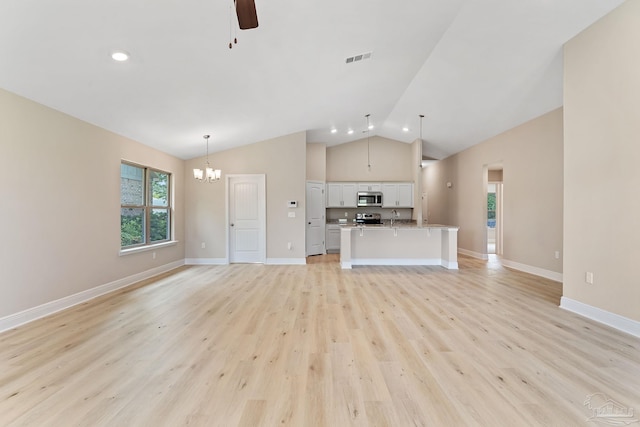 unfurnished living room with ceiling fan with notable chandelier, light hardwood / wood-style floors, lofted ceiling, and sink