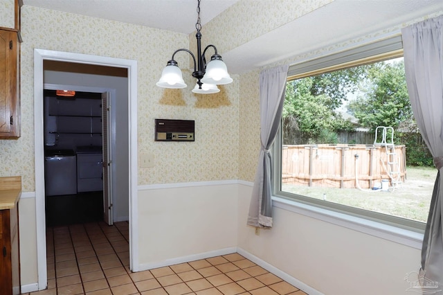 unfurnished dining area with wallpapered walls, light tile patterned floors, a chandelier, and wainscoting